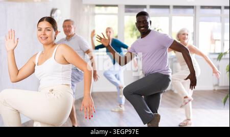Female instructor teaches mature students of dance class basic movements of hip hop dance Stock Photo