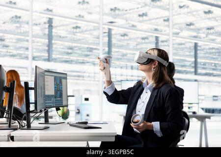 Engineer testing microchip electronics prototypes using VR technology. Worker wearing virtual reality headset ensures industrial hardware standards in semiconductors RD laboratory Stock Photo