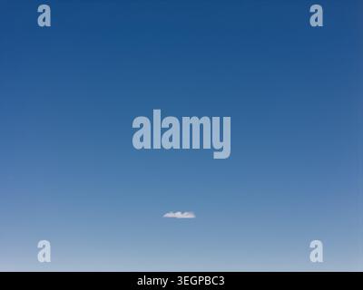 Blue sky with a single small cloud Stock Photo