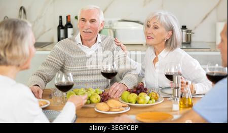 Couples of elderly women and men chatting and drinking Stock Photo