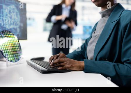 Close up of software developer in microchip factory RD office training AI model to optimize hardware. IT expert uses artificial intelligence to improve manufacturing efficiency Stock Photo