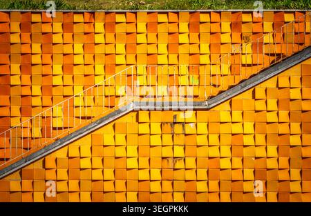 Bold geometric orange ceramic tile wall with diagonal staircase, Avenida Infante Santo, Lisbon, Portugal Stock Photo