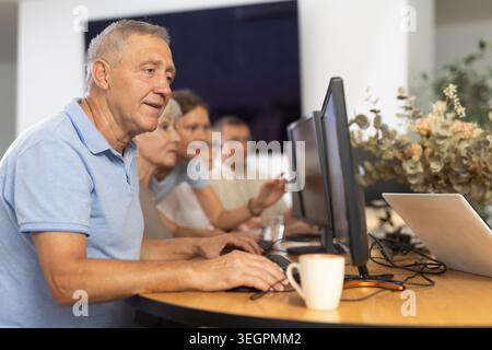 Enthusiastic senior man attending computer class for older adults Stock Photo
