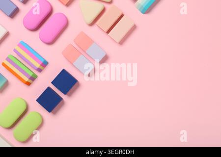 Many colorful rubber erasers on pink background Stock Photo