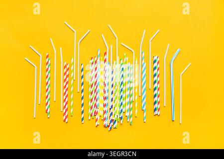Different drinking straws on orange background Stock Photo