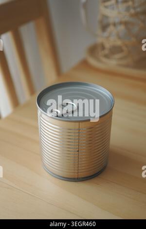 Can on wooden table with tab opened near window Stock Photo