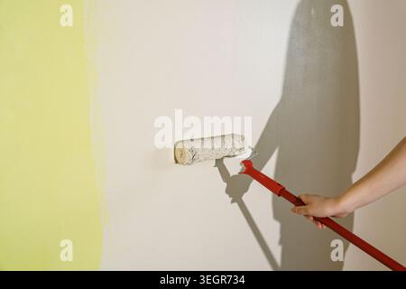 Painting wall with roller, home improvement and renovation concept, DIY painting project Stock Photo