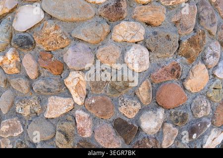 Seamless river rock wall background showcasing natural stone cladding texture and rustic tones Stock Photo