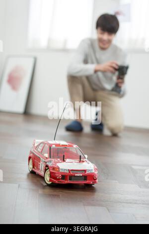 Smiling male kidult playing with toy car Stock Photo