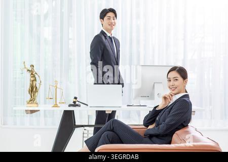 Two lawyers in a modern office smiling at each other while working together. Stock Photo