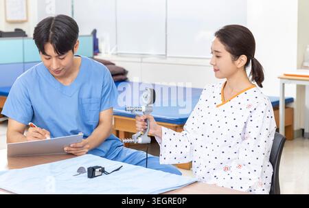 A doctor is taking a patient's blood pressure in a hospital room. Stock Photo