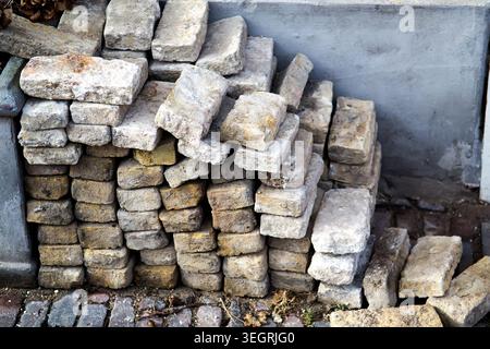 Pile of bricks on one of the city streets (taken by an old pavement) Stock Photo