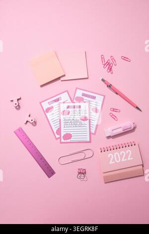A variety of pink office supplies and stationery are arranged on a pink background. Stock Photo