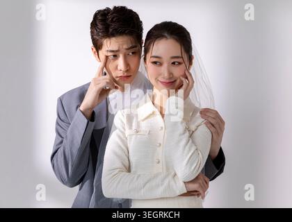 A young couple, dressed in formal attire, share a tender moment, their faces illuminated by soft, natural light. Stock Photo