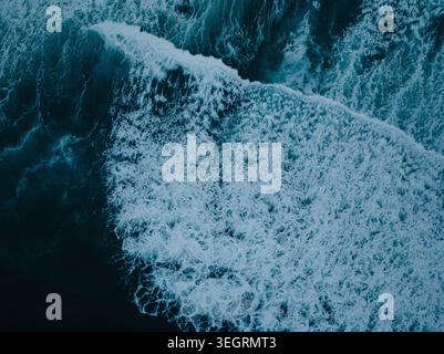 Aerial view of a powerful ocean wave breaking with white sea foam and deep blue water in San Diego, California, United States. Stock Photo