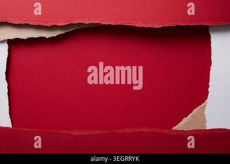 A red paper is torn in the middle, revealing a blank white space. Stock Photo