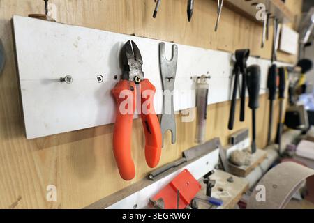 Workshop wall showcasing an organized collection of hand tools and various equipment hanging ready for use, reflecting concepts of work, craftsmanship Stock Photo
