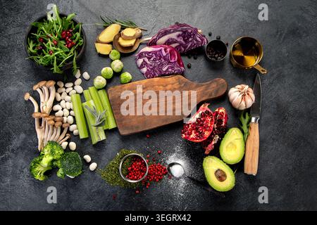Healthy food on dark background. Fresh vegetables, fruits, beans and spices. Vegan food preparing. Stock Photo