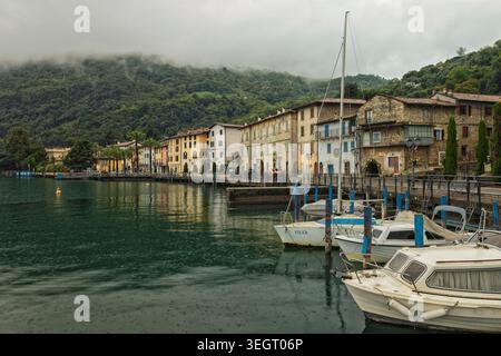 Lago d'Iseo, Italy - 03.10.2024: A picturesque view of traditional lakefront buildings and moored boats on the shores of Monte Isola, Lake Iseo, Italy Stock Photo
