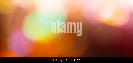 Colorful bokeh background with glowing mint pink and warm orange defocused lights for magical festive backdrop Stock Photo