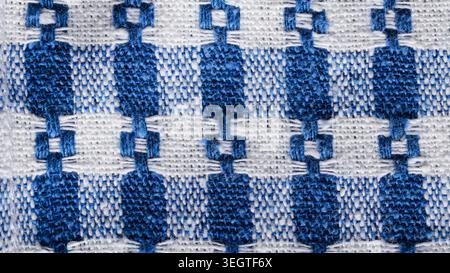Blue and white handwoven linen fabric with ornamental geometric pattern texture Stock Photo