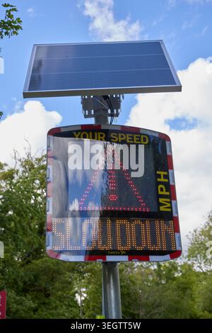 An Elan City speed indicator device (SID) displaying a “slow down” warning to a speeding driver on a UK roadside, used to improve road safety and enco Stock Photo