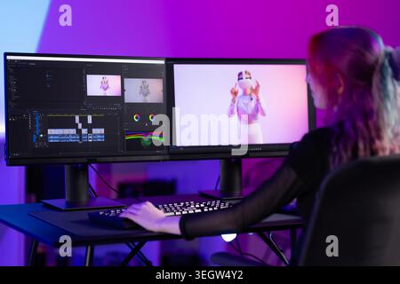 Young female video editor working on creative project with dual monitors Stock Photo