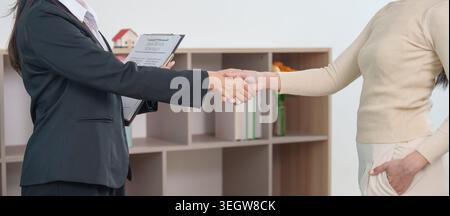 Asian women shaking hands after successful real estate deal Stock Photo