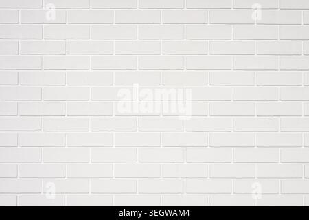 White painted brick wall providing a rough textured background, ideal for interior design and construction concepts Stock Photo