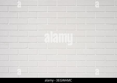 White painted brick wall providing a rough textured background, ideal for interior concepts design construction Stock Photo