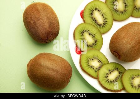 Freshly sliced kiwis on a white plate, arranged in a vibrant and healthy breakfast scene. Stock Photo
