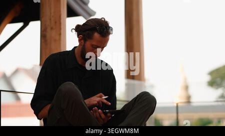 Man working remotely outdoors using tablet and stylus for creative design Stock Photo