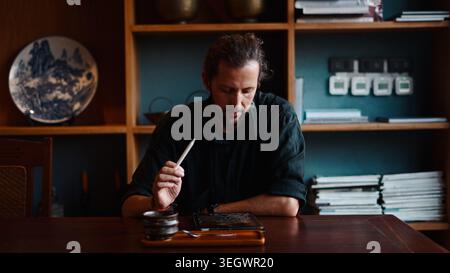 Man creating digital artwork on tablet with stylus, focused on design process Stock Photo