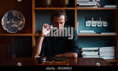 Creative designer analyzing digital artwork on a tablet, deeply concentrating at work Stock Photo