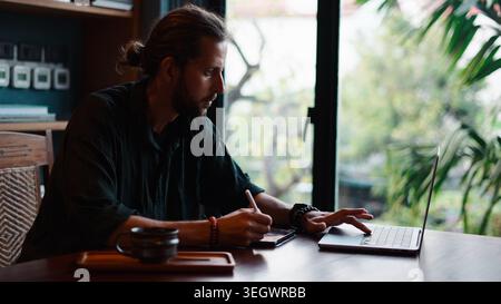 Young man focused on digital art and design, working from home with modern technology Stock Photo