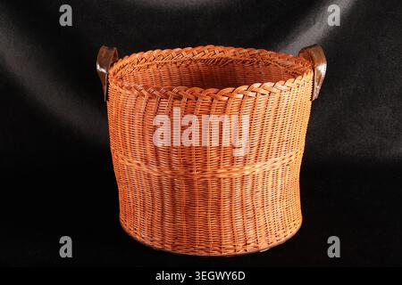 Handmade wicker basket on a black background. Stock Photo