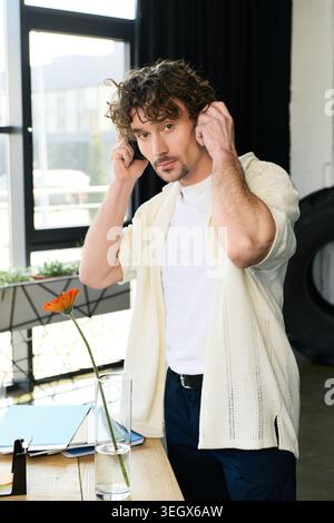 Confident man in an office, showcasing style and focus while preparing for work tasks. Stock Photo
