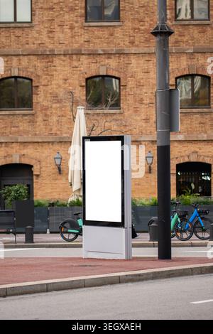 Blank advertising billboard mockup vertically displaying in an urban city street Stock Photo