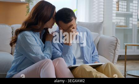 Caucasian man sad with laptop failure feeling stress woman supporting calming helping at home couple family relationship. Frustrated stressed male Stock Photo