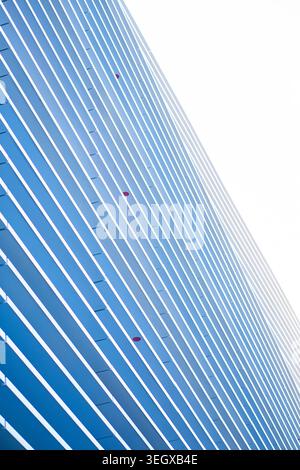 Modern building facade featuring abstract blue and white parallel lines Stock Photo