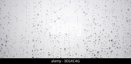 Drops of water on glass surface. Raindrops falling vertically Stock Photo