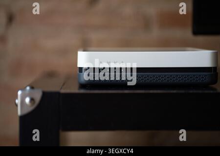 Modern Wi-Fi router sitting on a desk, connecting devices to the internet Stock Photo