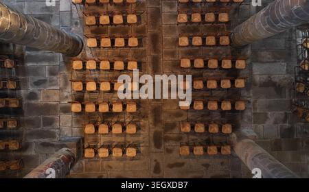 Aerial view of the interior of Eglise Saint-Melaine de Morlaix featuring rows of wooden chairs on a stone floor between massive stone pillars in Morla Stock Photo
