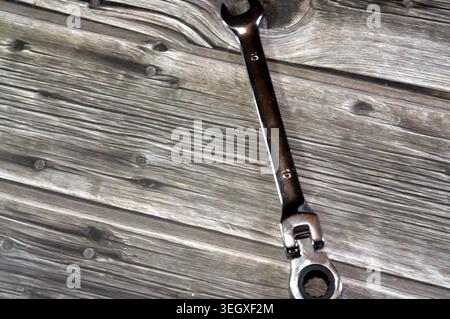 a flex-head combination ratcheting wrench, features a standard open-ended wrench on the left and a pivoting, ratcheting box end on the right Stock Photo