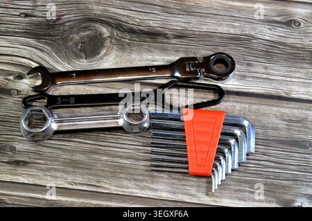 a set of hand tools including a flexible head ratcheting wrench, a specialized flat wrench, and a set of Allen keys Stock Photo