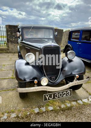 Vintage black Ford Model Y car parked on stone pavement under a cloudy sky Stock Photo