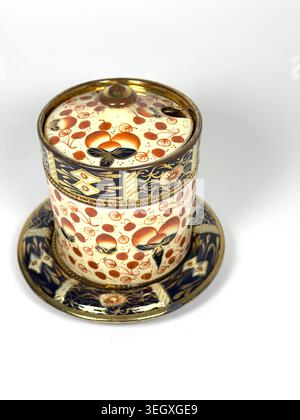 Antique English Imari style ceramic lidded jam pot  jar with matching saucer isolated on white background Stock Photo