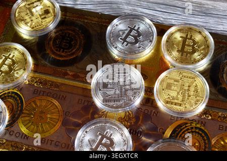Cairo, Egypt, May 14 2026: physical bitcoins, Bitcoin (BTC), on gold plated novelty 100 bitcoin BTC notes, features Vault door open on bitcoin symbol Stock Photo