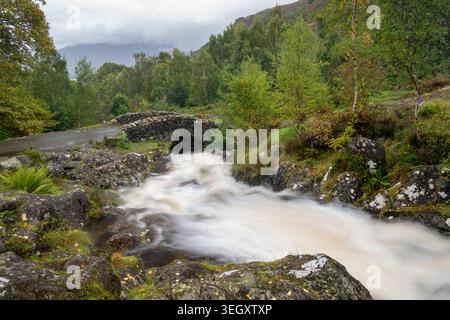 Ashness Bridge, an old packhorse bridge crossing  Borrow Beck in autumn, above Derwent Water in the Borrowdale valley, near Keswick, Cumbria, UK Stock Photo
