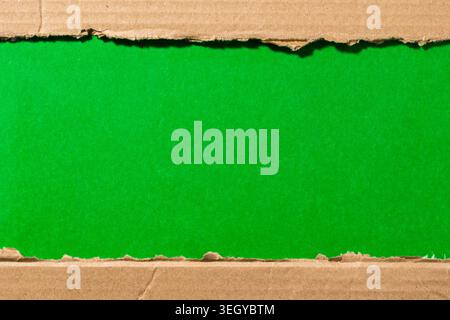 Torn brown corrugated cardboard paper showing a customizable green chroma key screen. Copy space area for concept or message, modern creative mockup Stock Photo